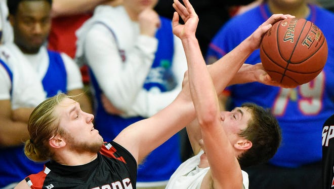 Rocori's Austin Overman (left) fouls Apollo's Ethan Novacinski as he takes a shot under the basket during the second half Saturday at Halenbeck Hall.