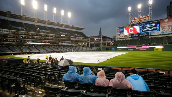 Fans wait during a rain delay in a baseball game between the Tigers and the Indians, Saturday in Cleveland.