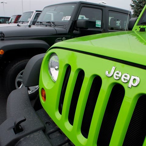 Jeeps sit for sale at a Chrysler dealership in...