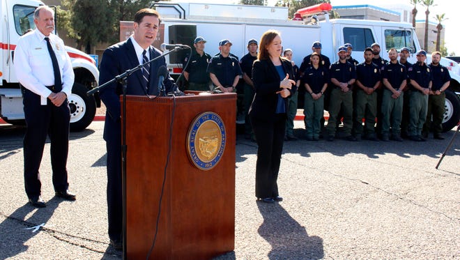 Arizona Gov. Doug Ducey speaks at a news conference on wildfire season as state Forester Jeff Whitney and fire crews look on Feb. 22, 2018, in Phoenix, Ariz. Whitney said the upcoming fire season could be one of the worst in his 45 years in firefighting because of the lack of rain across the state's grasslands, chaparral and pine forests.