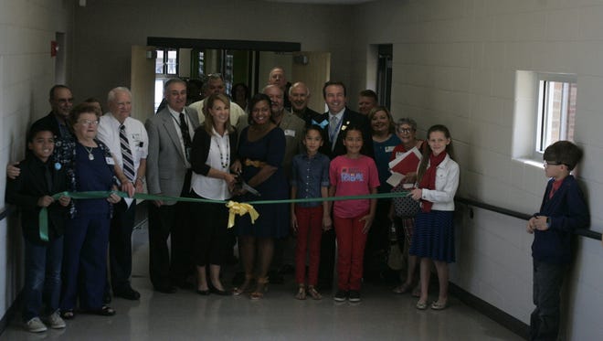 Former principal Polly Pewitt, left, and new principal Tiffany Dukes cut the ribbon, opening the new addition at Roy Waldron School.