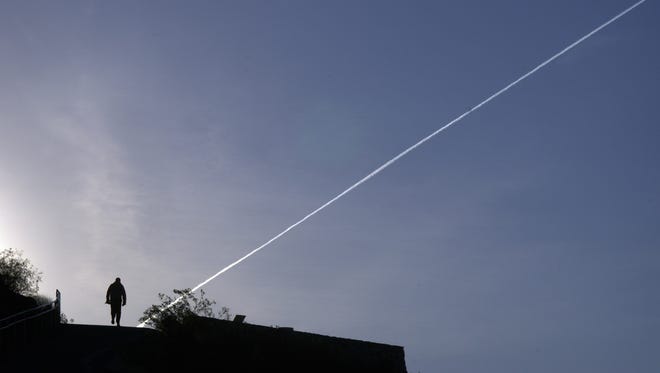 A jet contrail traces a line in the early morning sky over Tempe.