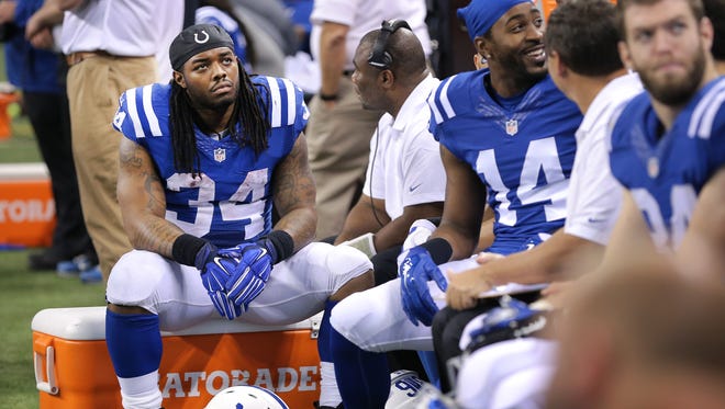 Indianapolis Colts running back Trent Richardson (34) sat on the sideline most of the game as teammate Indianapolis Colts running back Dan Herron (36) got most of the running action in the game against the Washington Redskins at Lucas Oil Stadium on Nov. 30.