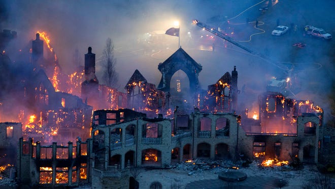 In this Friday, Jan. 10, 2014 file photo, firefighters battle a fire in Indian Hill, Ohio that destroyed the $4 million mansion. Chubb National Insurance Co. recently filed a lawsuit in federal court in Cincinnati in response to one filed earlier this year by the mansion's owners Jeffrey and Maria Decker. Chubb’s lawsuit says the Deckers made false statements about their fire losses and financial condition. (AP Photo/The Cincinnati Enquirer, Joseph Fuqua II, File)  MANDATORY CREDIT;  NO SALES