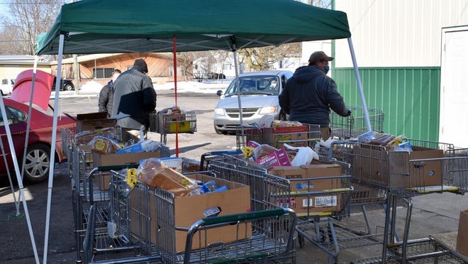Volunteers load cars with a weekly food box at Branch County Food Pantry on Pierson Street.