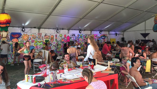 About 200 people were working on crafts at the Coachella Art Studios on Sunday, April 17. In the background, a mural by local artist Sofia Enriquez is embellished by festivalgoers.