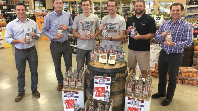 Creating the first retail display of Old Glory products Thursday were, from left, Paul Turner and Dustin Wallace from Ajax Distributing, brothers Wes and Matt Cunningham from Old Glory Distilling, Justin Crocker of Crocker's Fine Wines & Liquors, and Patrick Turner from Ajax Distributing.