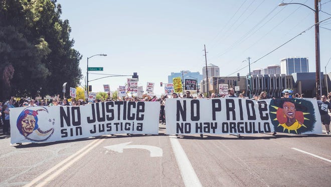 Members of Trans Queer Pueblo and their supporters march in the Phoenix Pride Parade on April 2, 2017. The group, which advocates for the rights of LGBT undocumented immigrants, says it wanted to temporarily disrupt the parade because it feels that Phoenix Pride has failed to ensure that the principles it espouses apply to everyone in Arizona's diverse LGBT communities.
