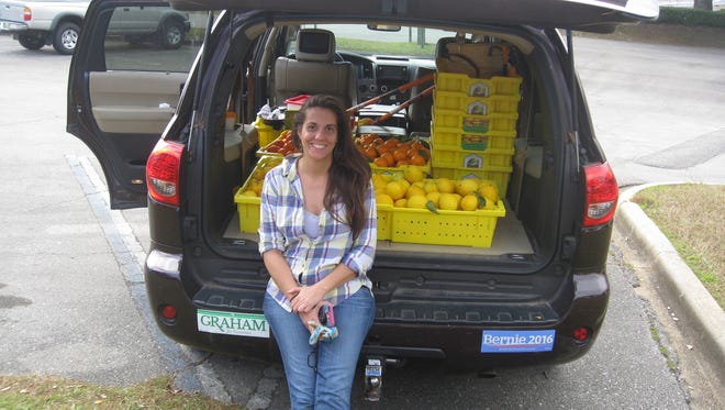 Tabitha Frazier with a harvest for the Leon Fruit and Nut Exchange.