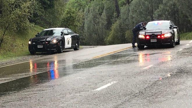California Highway Patrol officers talk near the closure at Placer and Muletown roads, where deputies are trying to stop a woman from jumping off a bridge.