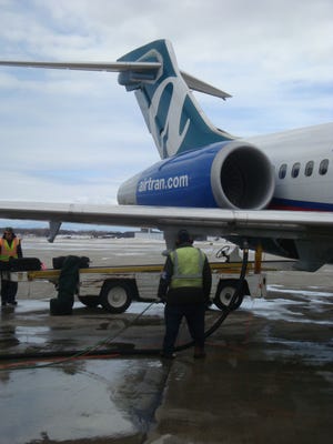 Workers refuel an AirTran Boeing 717 at Milwaukee's General Mitchell Airport in February 2010.