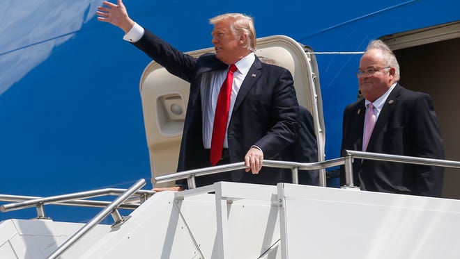 President Trump waves to the crowd at the Springfield-Branson Airport while accompanied by Rep. Billy Long and Sen. Roy Blunt (obscured) on Wednesday, August 30, 2017.