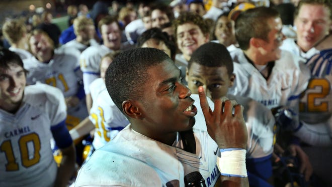 Carmel quarterback Isaac James celebrates with his team on the field after the Greyhounds defeated Warren Central 17-10 in the clash between Class 6A numbers 1 and 2 at Warren Central on Friday, October 10, 2014.