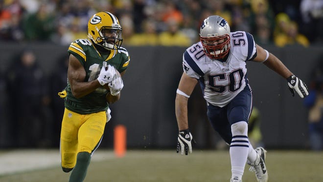 Green Bay Packers receiver Randall Cobb (18) makes a catch past New England Patriots defensive end Rob Ninkovich (50) in the second quarter during Sunday's game at Lambeau Field.