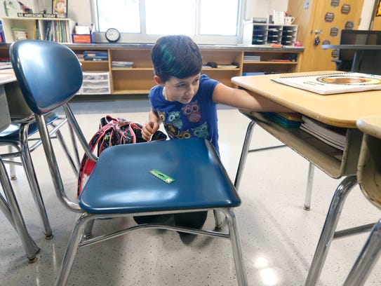 Gwen Giardina, 9, organizes her desk while taking a