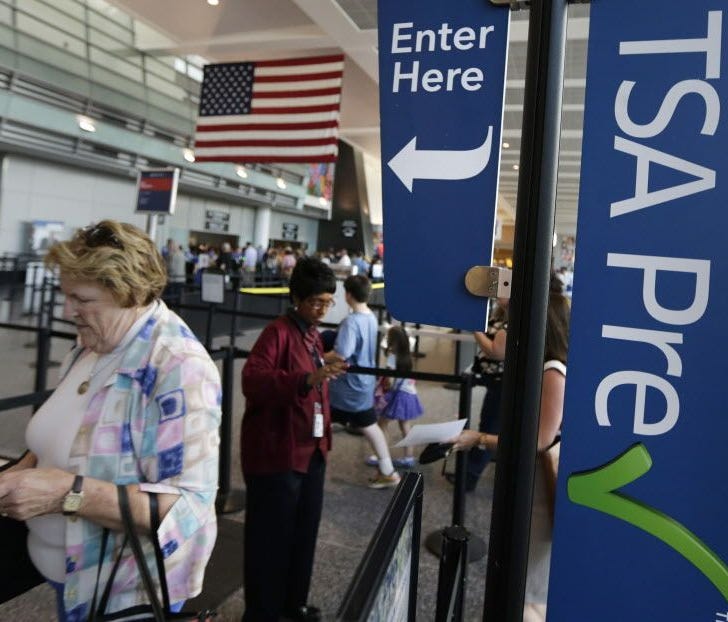 Travelers pass a sign for the Transportation Security Administration's TSA Precheck line as they walk to their departure gate in Terminal A at Logan International Airport on June 27, 2016, in Boston.