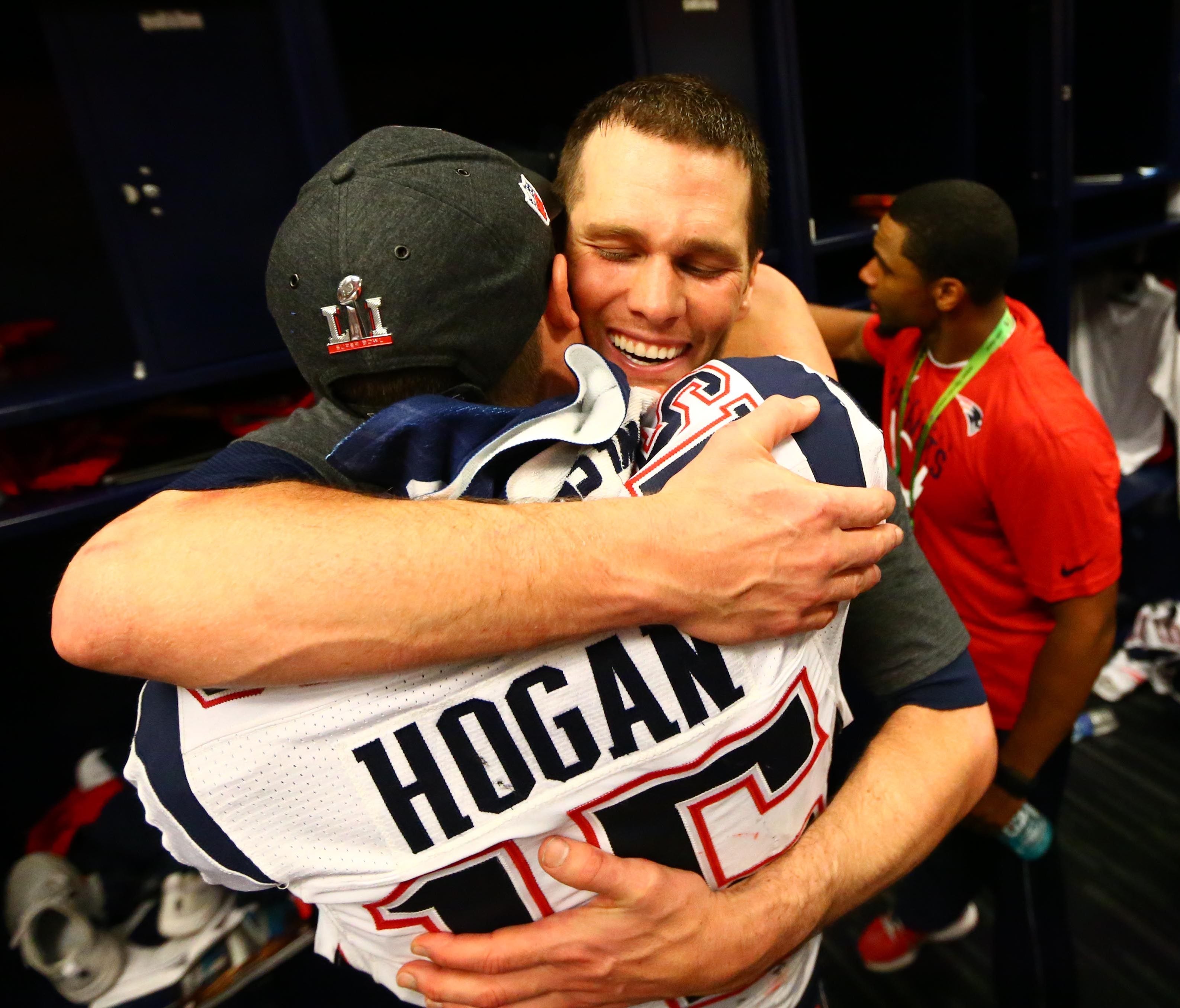 Tom Brady embraces Chris Hogan in the locker room after winning Super Bowl LI.
