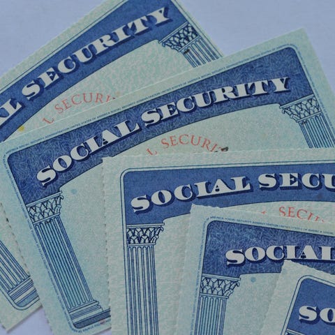 Loose stack of five Social Security cards lying on