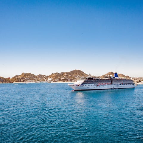 A cruise ship docked near an island port.