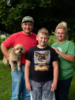 Mike and Teresa Cuckler and their son Layton, 11, take a portrait Aug. 14, 2020 in Piketon, Ohio. Their small farm is near the south gate of the former Portsmouth Gaseous Diffusion Plant.