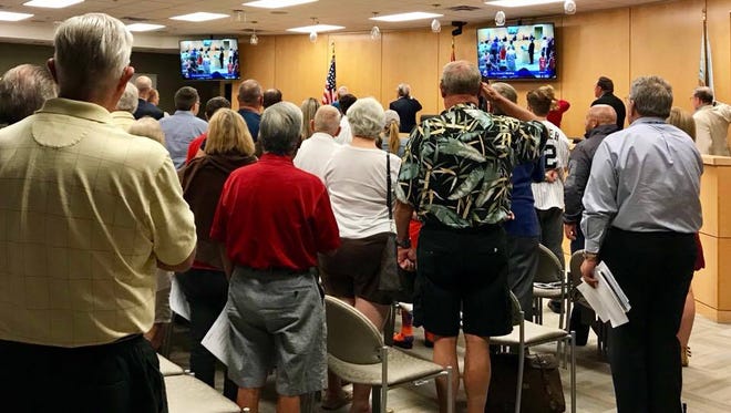 Marco Island residents and city councilors stand during the Pledge of Allegiance. The Marco Island City Council met at 5:30 p.m. Dec. 4.