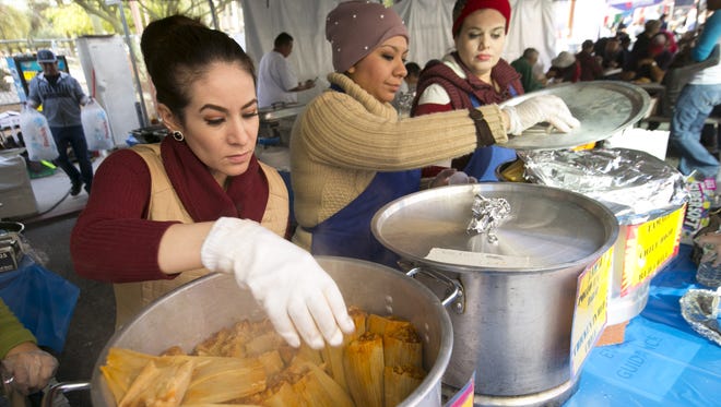 Elvira Hernandez pulls out hot tamales from a pot to serve to customers during the Food City Tamale Festival in downtown Phoenix on Dec. 10, 2016.