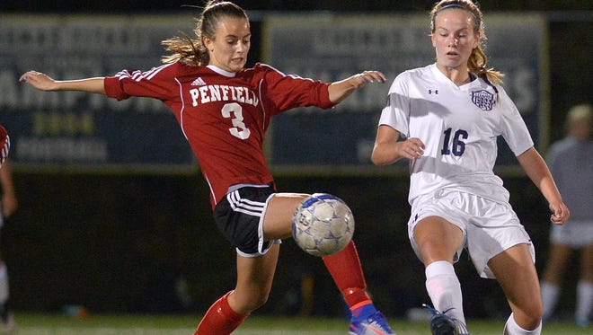 Webster Thomas' Sarah Riedel, right, clears the ball past Penfield's Grace Murphy.