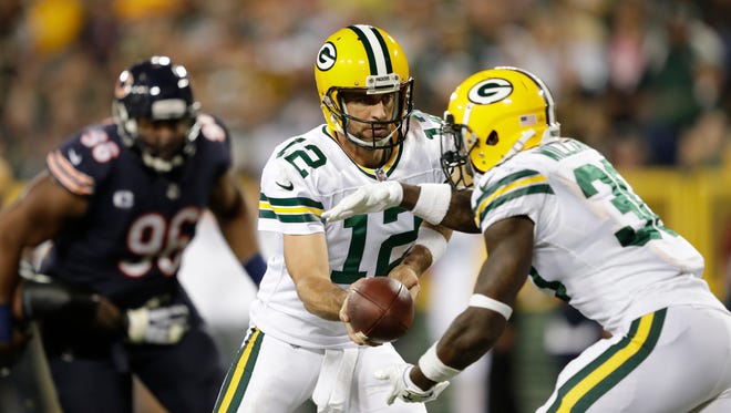 Green Bay Packers quarterback Aaron Rodgers (12) hands off to running back Jamaal Williams in the first half Thursday, September 28, 2017, at Lambeau Field in Green Bay, Wis.