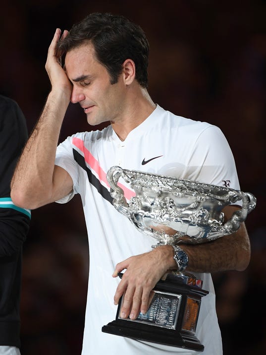 Switzerland's Roger Federer wipes a tear away as he holds his trophy after defeating Croatia's Marin Cilic in the men's singles final at the Australian Open tennis championships in Melbourne, Australia, Sunday, Jan. 28, 2018. (AP Photo/Andy Brownbill)