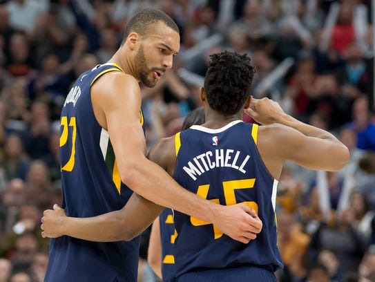 Rudy Gobert and Donovan Mitchell react during a timeout