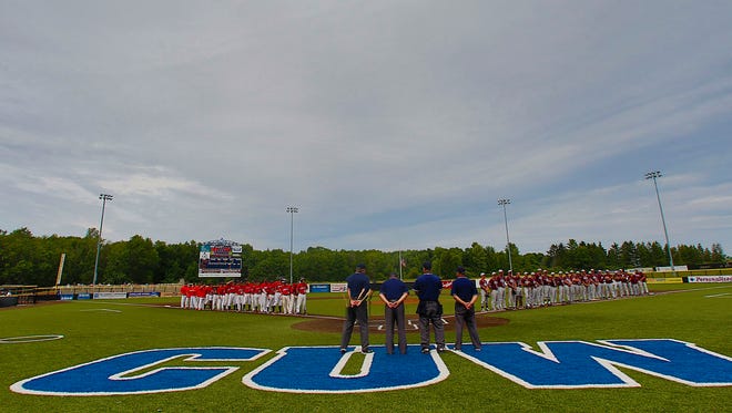 Pewaukee (left) and Menomonee Falls (right) stand along the base lines before the 2015 state baseball tournament at Kapco Park in Mequon.