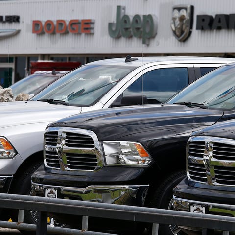 Ram pickup trucks sit on a dealership lot in Fairf
