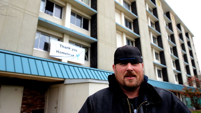Mike Karl stands outside the Magnusson Hotel  November, 19, 2015 in Lansing, Mich. A banner reading "Thank You Homeless Angels" is strung between two windows on the second floor of the hotel. Karl's organization, the Homeless Angels, uses the hotel to house people as they help them find permanent housing. They also provide other assistance to the area's homeless.
