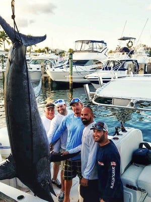 The Avilas and crew stand proudly with their 585-pound swordfish.