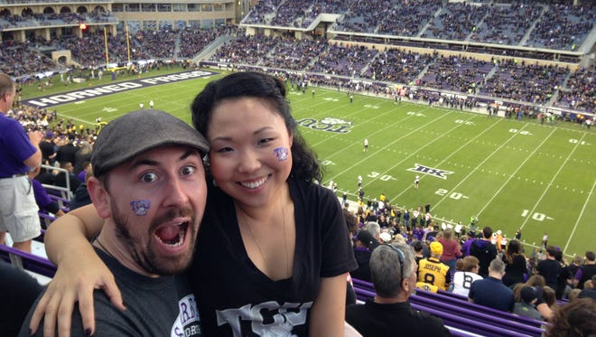 Erich England, left, and Saerom Yoo attend the TCU-West Virginia football game at the Amon G. Carter Stadium on Oct. 29, 2015.