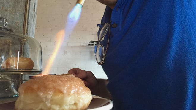 Edward Zachary Graham torches the topping of a creme brulee donut.