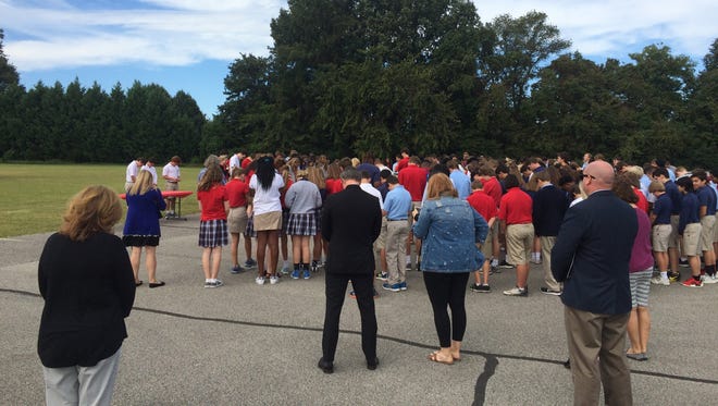 A group of students and teachers at University School of Jackson pause for prayer while remembering 9-11 on Monday.