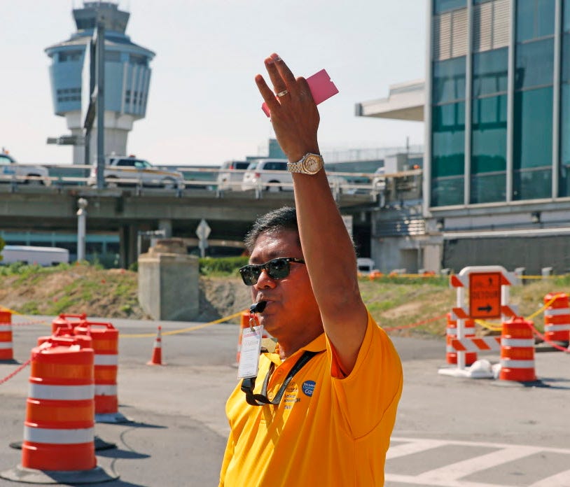 A Port Authority customer care representative directs traffic Aug. 24, 2016, during the $4 billion renovation project at LaGuardia Airport in New York. Demolition of an existing parking garage and the construction of two new ones has added to the nor