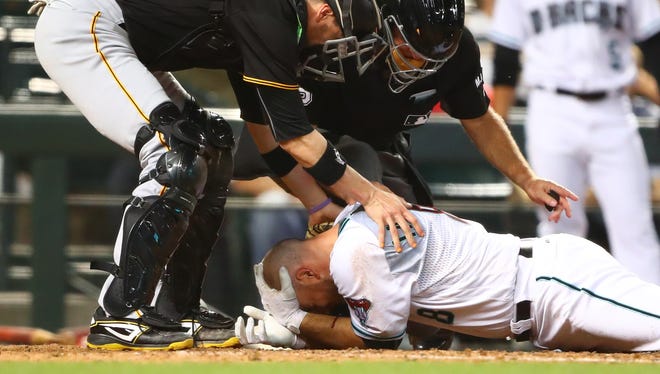 May 12, 2017: Pittsburgh Pirates catcher Chris Stewart (left) tends to Arizona Diamondbacks catcher Chris Iannetta as he lays on the ground after being hit in the face by a pitch in the seventh inning at Chase Field.