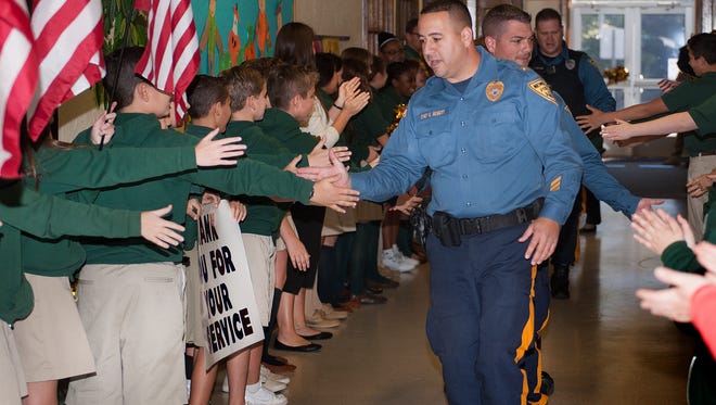 Newfield Police Chief, Edward Seibert, leads the line as police shake in the good luck gauntlet, Tuesday, Oct. 17, 2017, with students from Edgarton Christian Academy. Students honored Newfield Police, which apparently disband on Nov. 1. 
