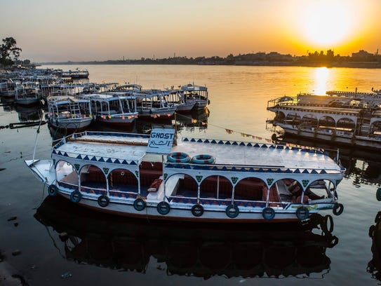 River boats are moored in the Nile at a marina at sunrise