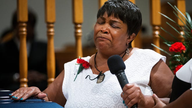 Johnny Ray Johnson's mother, Lentory Johnson, lays her hand on her son's casket as she talks about his life during a celebration of life service at Ebenezer Baptist Church on Thursday, August 27, 2015. "He wasn't perfect, but he was mine," she said. 