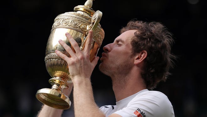 Andy Murray of Britain kisses his trophy after beating Milos Raonic of Canada in the men's singles final on day fourteen of the Wimbledon Tennis Championships in London, Sunday, July 10, 2016. (Andy Couldridge/Pool Photo via AP)