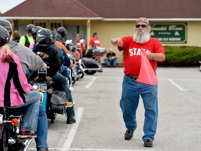 Bill Strickler of Dover Township directs arriving motorcyclists