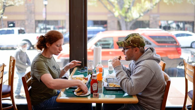 Annie Ponstingl, left, and Lewis Peacock eat burgers at Bruni's Breakfast & Burgers during a grand opening Friday, April 20, 2018 in Vineland, N.J.
