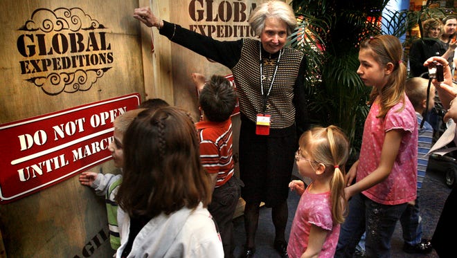 Julia Lacy, former chair of the Children's Museum Board of Trustees, talks to youth before the unveiling of the National Geographic Treasures of the Earth exhibit.