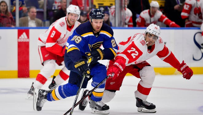 Blues center Kyle Brodziak and Red Wings left wing Andreas Athanasiou battle for the puck during the first period at Scottrade Center on Wednesday.