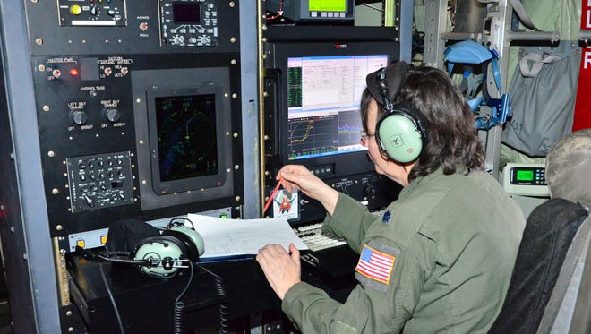 Lt. Col. Valerie Hendry, an aerial reconnaissance weather officer with the 53rd Weather Reconnaissance Squadron checks data during winter storm "Iola"  last week.