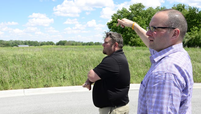 Steven Fought, mayor of Gibsonburg, left, and Marc Glotzbecker, Village administrator, stand in front of a proposed site at Clearview industrial Park for a new medical marijuana processing plant.