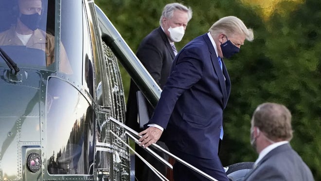 President Donald Trump arrives at Walter Reed National Military Medical Center, in Bethesda, Md., Friday, Oct. 2, 2020, on Marine One helicopter after he tested positive for COVID-19. White House chief of staff Mark Meadows is at second from left.